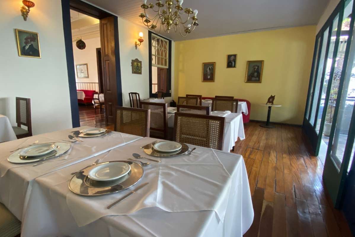 Salão com paredes amarelas e quadros antigos