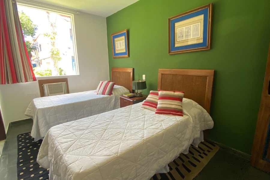 Quarto com parede verde e duas camas