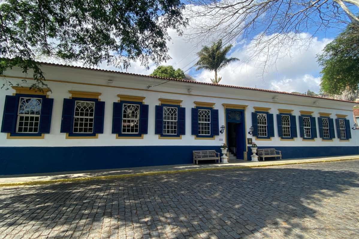 Fachada lateral do Mara Palace Hotel com rua de paralelepípedos