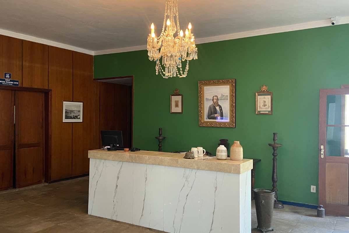 Recepção com parede verde e lustre